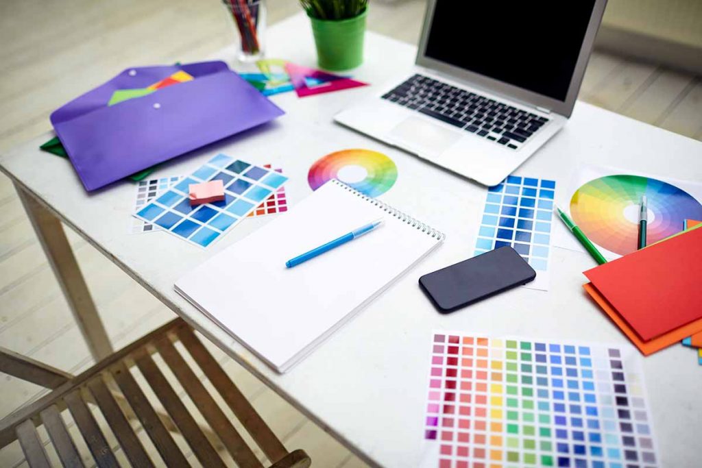 a selection of print colour palettes and computer on a table